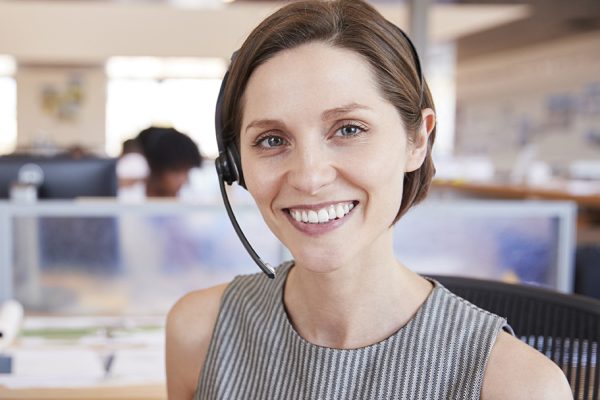 Young white woman working in a call centre smiling to camera